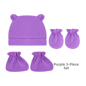 Gros plan de l'ensemble 3 pièces violet pour nouveau-né avec bonnet, moufles et chaussettes