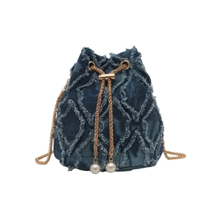 Denim bucket bag with frayed fringe diamond pattern and gold chain pearl drawstring