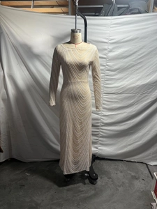 Detail of champagne sequin gown showing intricate geometric wave patterns and slim fit