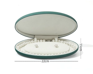 Green oval velvet jewelry box showing white pearl necklace and earrings, 22cm length