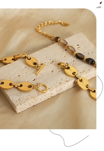 Détail de la chaîne vintage dorée avec perles d'agate sur un tissu de soie luxueux