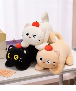 Three plush cat dolls with apple hats in white, black and orange on a white desk