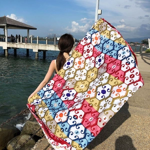 Ethnic style long red shawl scarf featuring colorful geometric patterns on a beach pier