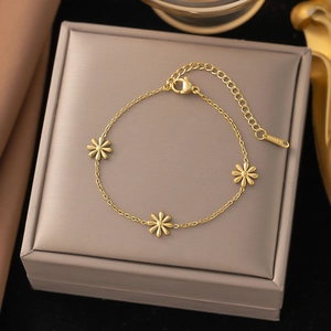 Detail of a gold stainless steel daisy bracelet on a jewelry display box