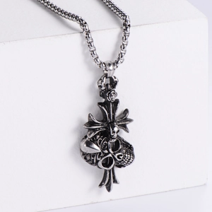 Close-up of vintage silver skull and cross pendant with rose detail on round link chain