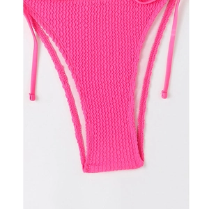 Detailed macro view of bright pink seersucker bikini bottom with side tie straps