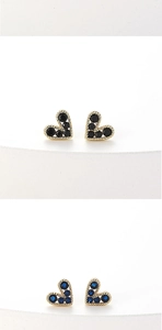 Detailed view of heart-shaped stud earrings in gold with black and blue gemstones
