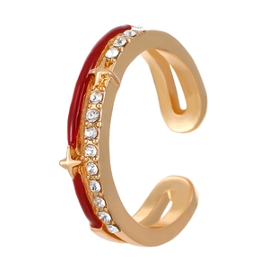 Detail of gold ear cuff with red enamel coating and shimmering cubic zirconia stars