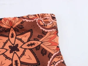 Gros plan sur l'imprimé cachemire bohème et les coutures élastiques de la robe marron