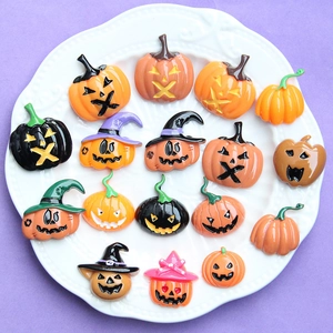 Ciondoli in resina per Halloween con zucche e cappelli da strega colorati su piatto