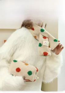 Close-up of rainbow polka dot plush scarf and matching cosmetic bag in soft cream fleece