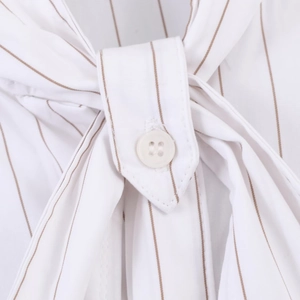 Detail of white and brown striped poplin shirt with a button and tie-neck design