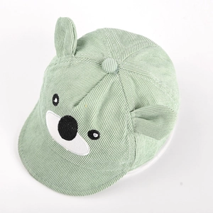 Détail macro du bonnet bébé en velours côtelé vert clair avec oreilles d'ours et broderie