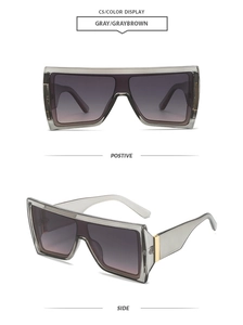 Detail view of modern oversized butterfly sunglasses with gradient grey lenses in clear frames