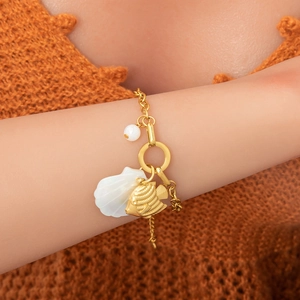 Détail de breloques coquillage et poisson en plaqué or 18K sur un bracelet marin