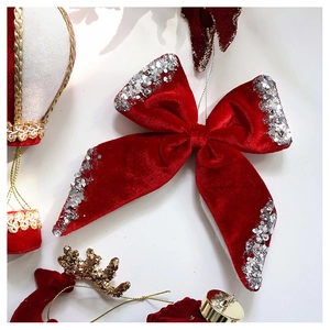 Detail of red velvet bow with silver sequins and hot air balloon Christmas ornaments