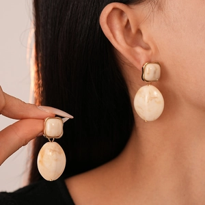 Elegant marble-textured resin earrings in cream and gold with oval and square pendants
