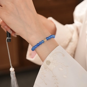 Detail of blue apatite beaded bracelet on wrist with a yellow crystal charm