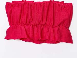 Vue détaillée du crop top fuchsia smocké avec texture plissée et ourlet volanté