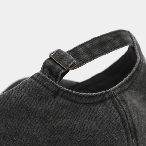 Close-up of washed baseball cap back with adjustable metal buckle and cotton strap