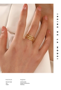 Gros plan d'une bague tressée ajourée plaquée or 18 carats sur fond de soie élégante