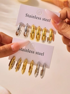 Macro shot of gold and silver two-tone stainless steel geometric hoop earrings on display card