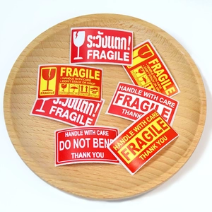 Fragile warning labels on a wooden tray for shipping packages with English and Thai text