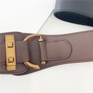 Detail shot of the wide brown vintage waist belt with golden D-ring buckle and stitching