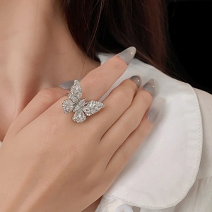 Bague papillon argentée avec zircons brillants portée par un mannequin pour un look de luxe