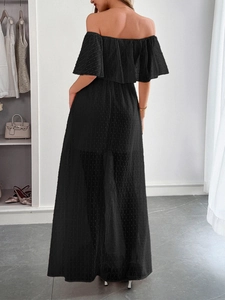 Vista posteriore di un abito lungo nero a spalle scoperte con elegante motivo a pois in chiffon