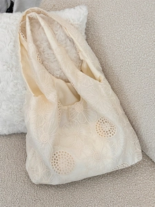 Artistic off-white canvas tote bag featuring floral embroidery and cutout details
