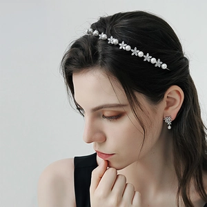 Detail shot of elegant pearl and zircon flower headband with matching earrings on model