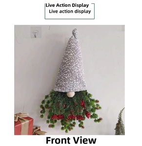 Vue de face d'un gnome de Noël décoratif avec des baies rouges et épines de pin