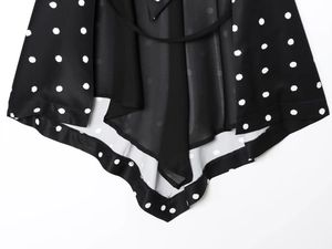 Detail of black and white polka dot chiffon fabric with an irregular hemline cut