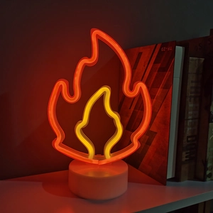 Orange and yellow LED flame neon sign lamp with white base on a shelf for cozy room decor