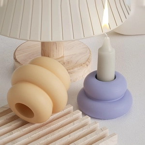Detailed close-up of matte ceramic candlestick holders with round wavy layered design