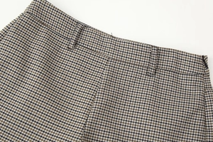 Detail of high-waisted houndstooth plaid shorts with woven texture and belt loops