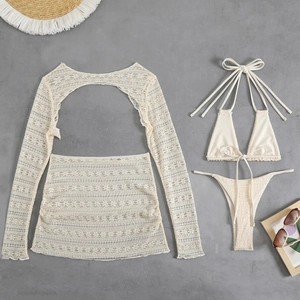 Flat lay of cream lace beach set with long sleeve cover-up and matching bikini suit