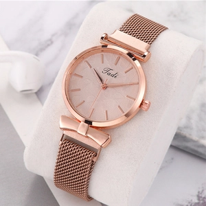 Close-up of rose gold ladies quartz watch with magnetic Milanese band and bow detail