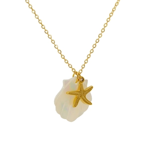 Detailed shot of golden starfish pendant and iridescent shell on a delicate O-chain