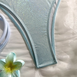 Macro view of light blue sequined bikini bottom with shimmering fabric and precise stitching