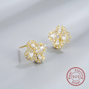 Macro shot of 925 sterling silver four-leaf clover earrings with sparkling zircon stones