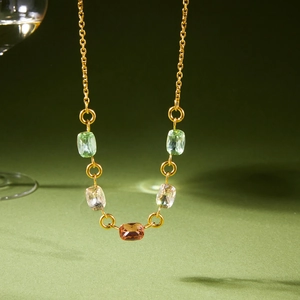 Elegante collana in acciaio al titanio dorato con cristalli rettangolari colorati su verde