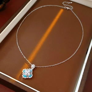 Macro detail of silver necklace with sky blue zircon flower pendant on jewelry box