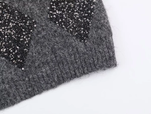 Primer plano de tejido de punto gris oscuro con textura suave y lentejuelas negras