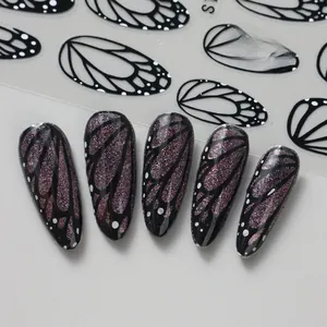 Detailed view of butterfly wing nail stickers with purple glitter and black outlines