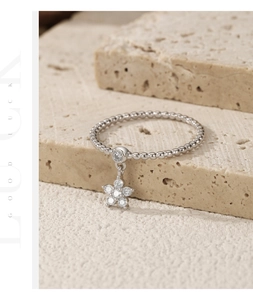 Macro detail of S925 sterling silver ring with sparkling star flower charm pendant