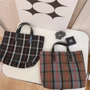 Macro shot of British style plaid tote bags with leather handles and rivet details
