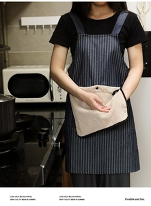 Close-up of blue striped apron with beige absorbent hand towels and denim fabric texture