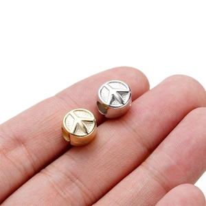 Golden and silver CCB plastic peace sign spacer beads for DIY jewelry making in hand